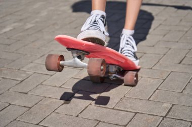 Kaykaylı genç bir kadın. Pembe. Güneş gölgesi