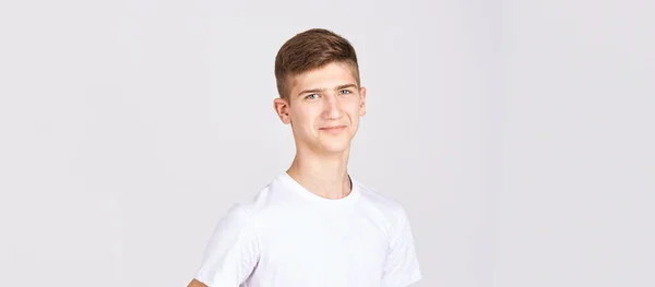 Retrato de adolescente. Hombre joven en el estudio. Mira la cámara. Camiseta blanca —  Fotos de Stock