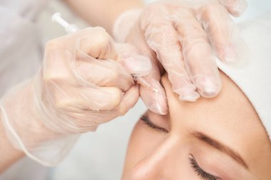 Spa salonunda alın enjeksiyonu. Doktor elleri. Güzel bayan hasta..