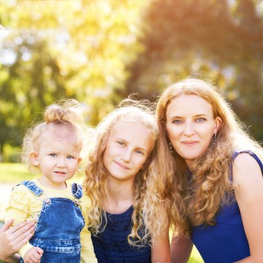 Anne ve küçük kızları. Mutlu aile fotoğrafı. Anne sarılması. Açık hava yaşam tarzı