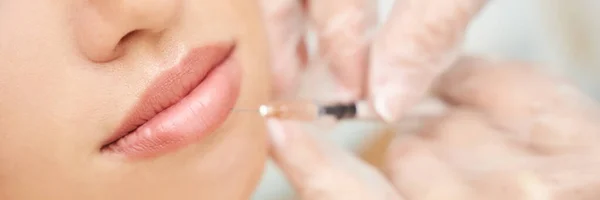 Lippenspritzen im Wellness-Salon. Arzthände. Nahaufnahme. Hübsche Patientin — Stockfoto