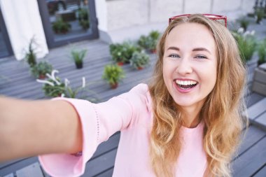 Dışarıda kendi portresini yapan genç bir kadın. Şehir tatil portresi