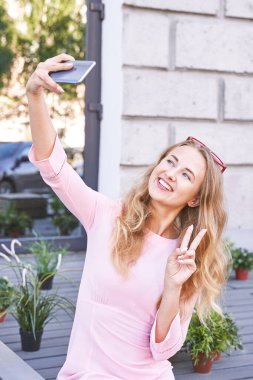 Dışarıda kendi portresini yapan genç bir kadın. Şehir tatil portresi