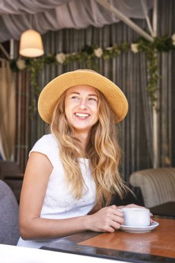 Caddedeki kafede kahve içen genç bir kadın. Konaklama turisti