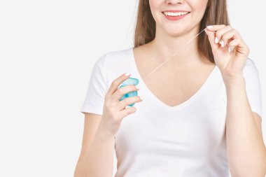 Diş ipi tutan genç bir kadın. Diş sağlığı konsepti. Güzel gülen surat.