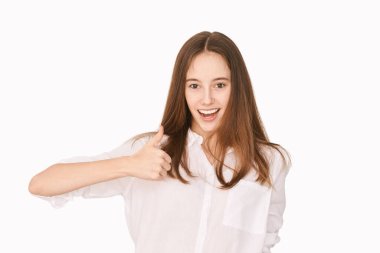 Mutlu gülümseme duygusu. Bir jest gibi baş parmak yukarı. Çekici bir genç.