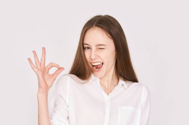 Mutlu gülümseme duygusu. Tamam jestini onayla. Çekici bir genç. Göz kırp