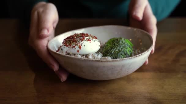 Gesundes Essen im veganen Café. Grüner Buchweizen mit pochiertem Ei und Avocado. — Stockvideo