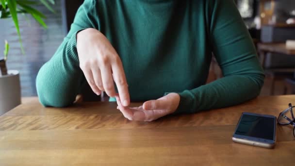 Csinos nő ül a kávézóban és beszél. Zöld ruha hosszú ujjakkal — Stock videók