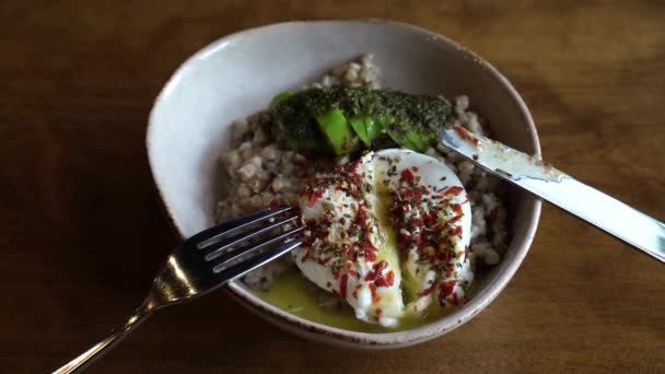 Comida saludable en la cafetería vegana. Alforfón verde con huevo escalfado y aguacate. — Vídeos de Stock