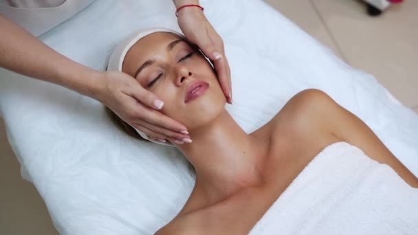 Massaggio viso al salone spa. Le mani del dottore. Una bella paziente. Trattamento di bellezza — Video Stock