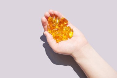 Omega3 jel kapsülü. Güneş gölgesi. Sarı vitamin. Sağlıklı beslenme. Diyetoloji ilacı.