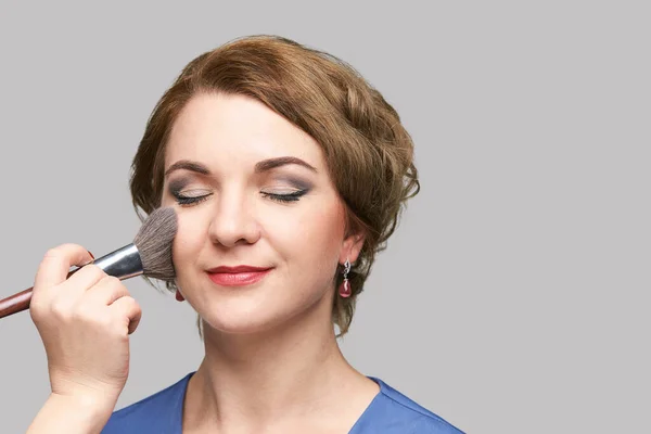 Vrouw doet make-up. Gezicht cosmetische borstel. Huidverzorging. Gezichtsaansteker. Mascara. — Stockfoto