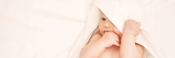 Leuke kleine jongen liggend aan bed. Een kinderbad concept. Lichte achtergrond — Stockfoto