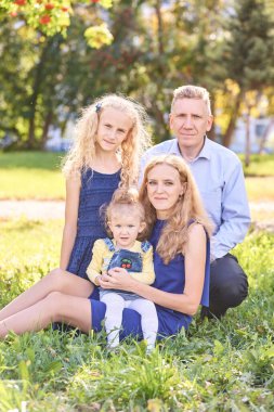 Parkta iki küçük kızı olan ebeveynler. Aile fotoğrafı. Doğa yaşam tarzı