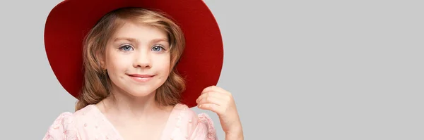 Little cute girl in pink dress and red head. Studio portrait — Stock Photo, Image