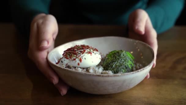 Healthy food at vegan cafe. Green buckwheat with poached egg and avocado. — Stock Video