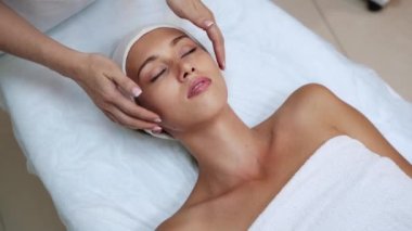 Kaplıca salonunda yüz masajı. Doktor elleri. Güzel bir bayan hasta. Güzellik tedavisi