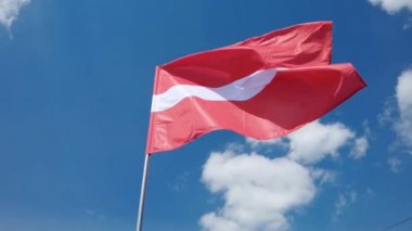 Mavi gökyüzü arka planında ulusal ülke bayrağı. Uçan kumaş sembolü