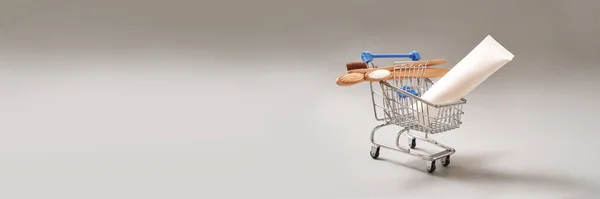 Szürke hátterű ökológia fogkefe. Különböző színű a bevásárlókocsiban — Stock Fotó