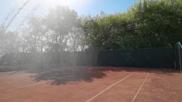 Pista de tenis con aspersores. Riego de tapa dura. Color marrón. — Vídeo de stock