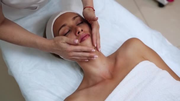 Massaggio viso al salone spa. Le mani del dottore. Una bella paziente. Trattamento di bellezza — Video Stock
