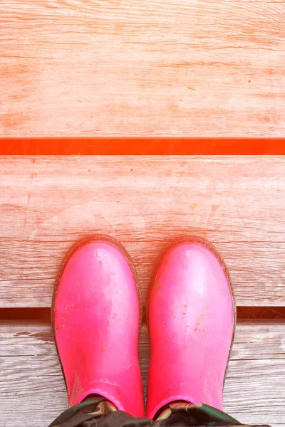 Uma poça cor de rosa. Chuva botas brilhantes. Sapatos de segurança sujos. Tempo de verão — Fotografia de Stock