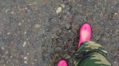 Pembe su birikintisi. Parlak çizmeler. Kirli güvenlik ayakkabıları. Yaz havası. Yürümek.