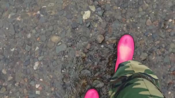 Pink puddle. Rain bright boots. Dirty safety shoes. Summer weather. Walking — Stock Video