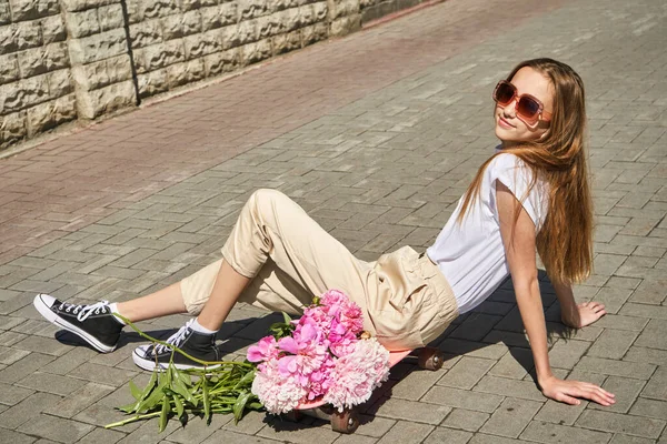 Chica con monopatín. Paisaje urbano. Zapatillas negras. Nuevo viaje normal — Foto de Stock