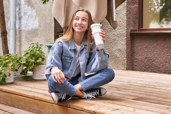 A csinos lány a szabadban iszik. Vegyél elvitelre való kávét saját pohárban. Valódi emberek — Stock Fotó