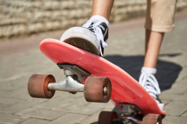 Kaykaylı kız. Şehir manzarası. Siyah spor ayakkabılar. Yeni normal seyahat