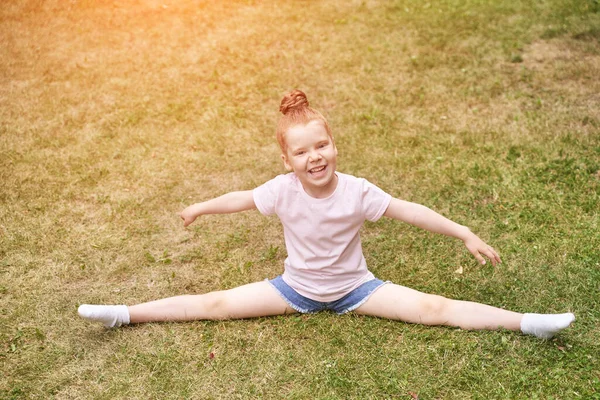 Cara bonita. Cabelo vermelho. Criança da escola bonito fazendo exercício de ioga. Férias activas — Fotografia de Stock