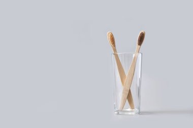 Gri arka planda ekoloji diş fırçası. Camdaki fırça. Sürdürülebilir ağız ürünü