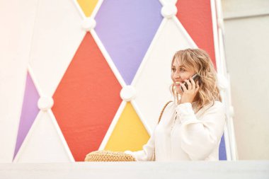 Telefonla konuşan genç ve güzel bir bayan. Dışarıda mutlu bir kadın var. Yaz