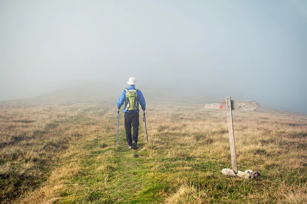 Homem trekking no nevoeiro — Fotografia de Stock