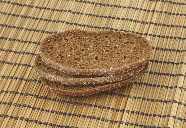 Pieces of bread on a bamboo napkin. — Stock Photo, Image