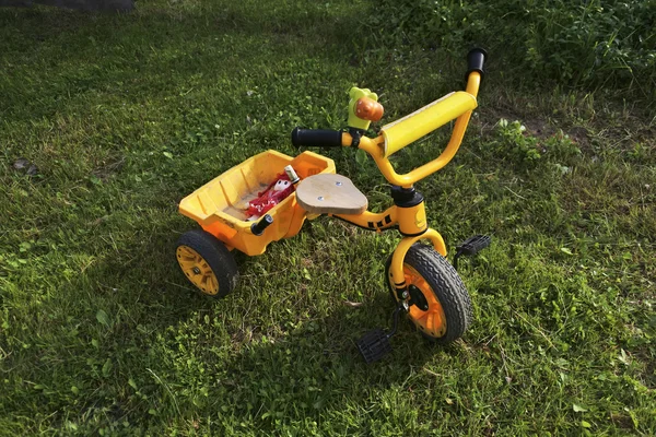 Çocuk sarı Bisiklet çimenlerin üzerinde. 