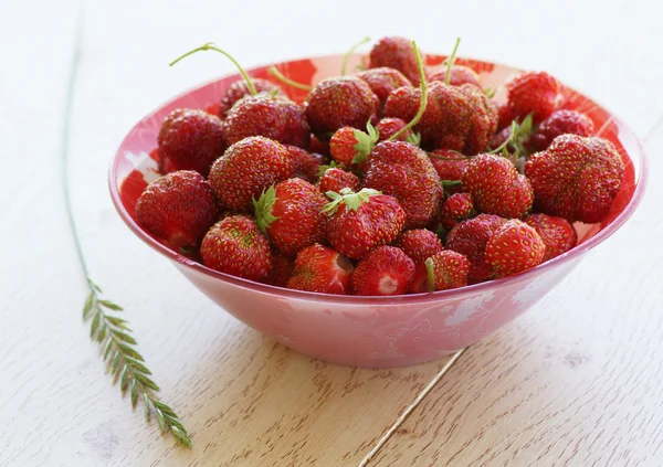 Strawberries in a plate on a wooden surface. — Stock Photo, Image