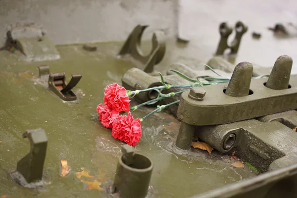 Herdenkingsmunt bloemen liggen op de tank. — Stockfoto