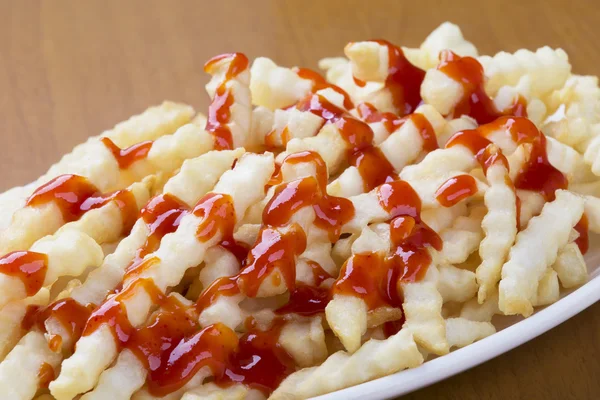 Delicious crinkle cut style french fries with ketchup — Stock Photo, Image