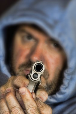Thief or gang member holding a handgun in a threatening position clipart
