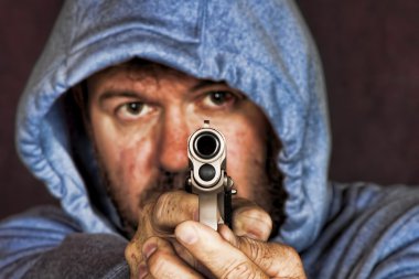 Thief or gang member holding a handgun in a threatening position clipart