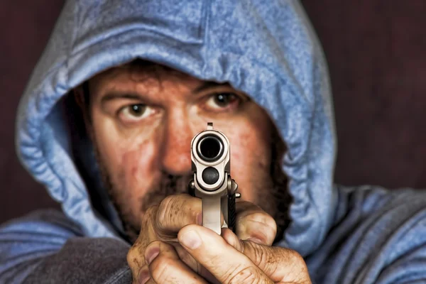 Ladrón o pandillero sosteniendo una pistola en una posición amenazante — Foto de Stock