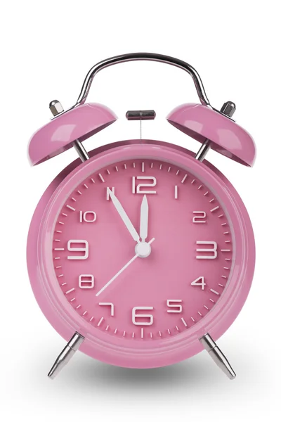 Reloj despertador rosa con las manos a 5 minutos hasta las 12. Ilustrando el tiempo se está acabando aislado sobre un fondo blanco —  Fotos de Stock