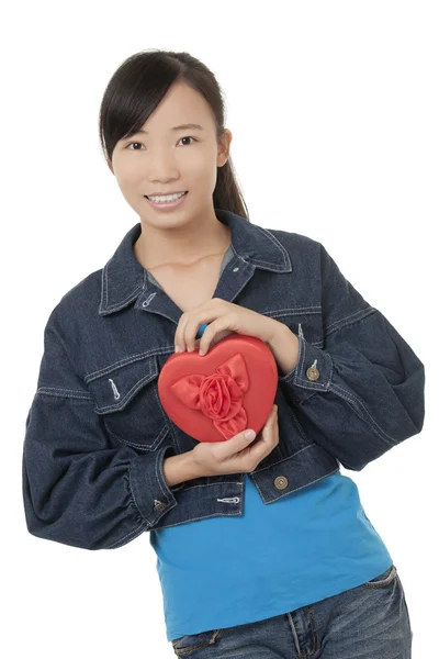 Mulher chinesa bonita segurando um coração vermelho e flertando com alguém isolado em um fundo branco — Fotografia de Stock