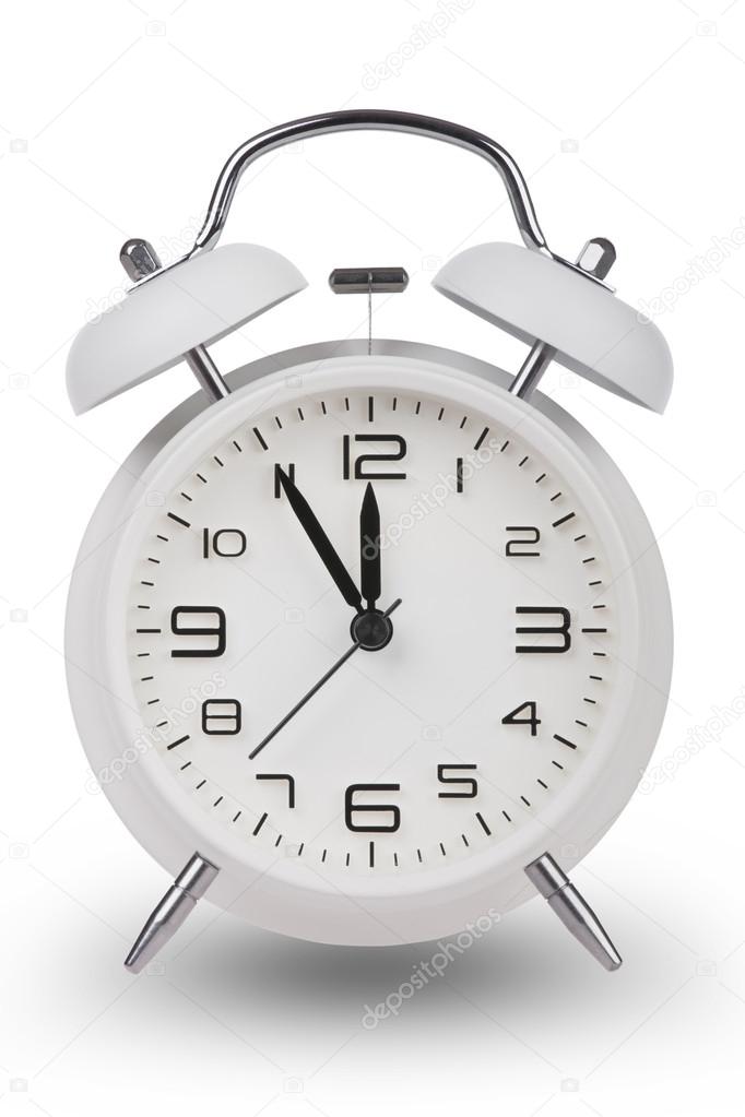 White alarm clock with the hands at 5 minutes till 12. Illustrating Time is Running Out isolated on a white background