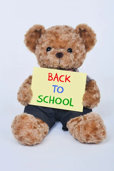 Cute teddy bear bedrijf een geel terug naar School teken geïsoleerd op een witte achtergrond — Stockfoto