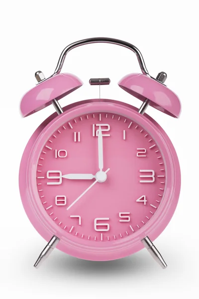 Reloj despertador rosa con las manos a las 9 am o pm aislado sobre un fondo blanco . —  Fotos de Stock