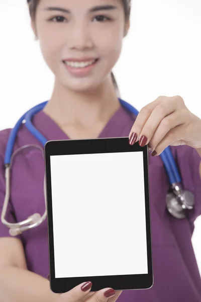 Kaunis aasialainen lääkäri tai sairaanhoitaja, jolla on tabletin tietokone, joka hymyilee kameralle eristettynä valkoisella taustalla. Kanssa clippimg polku valmis lisäämään tekstiä tai kopioida — kuvapankkivalokuva